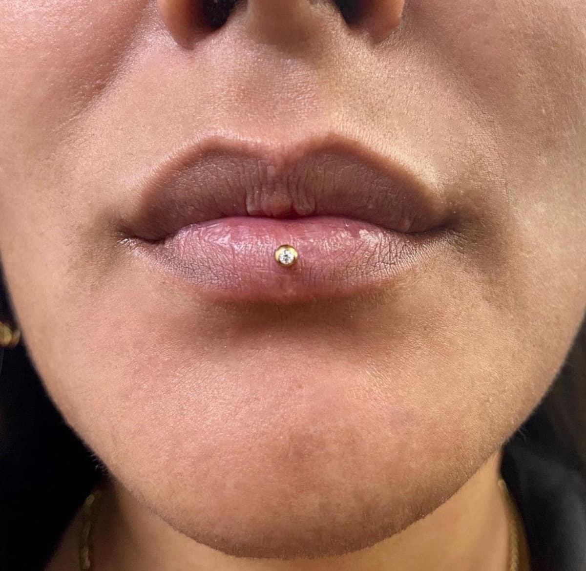 Lip piercing with black spike circular barbell and star labret piercing at Apollo Studio LA