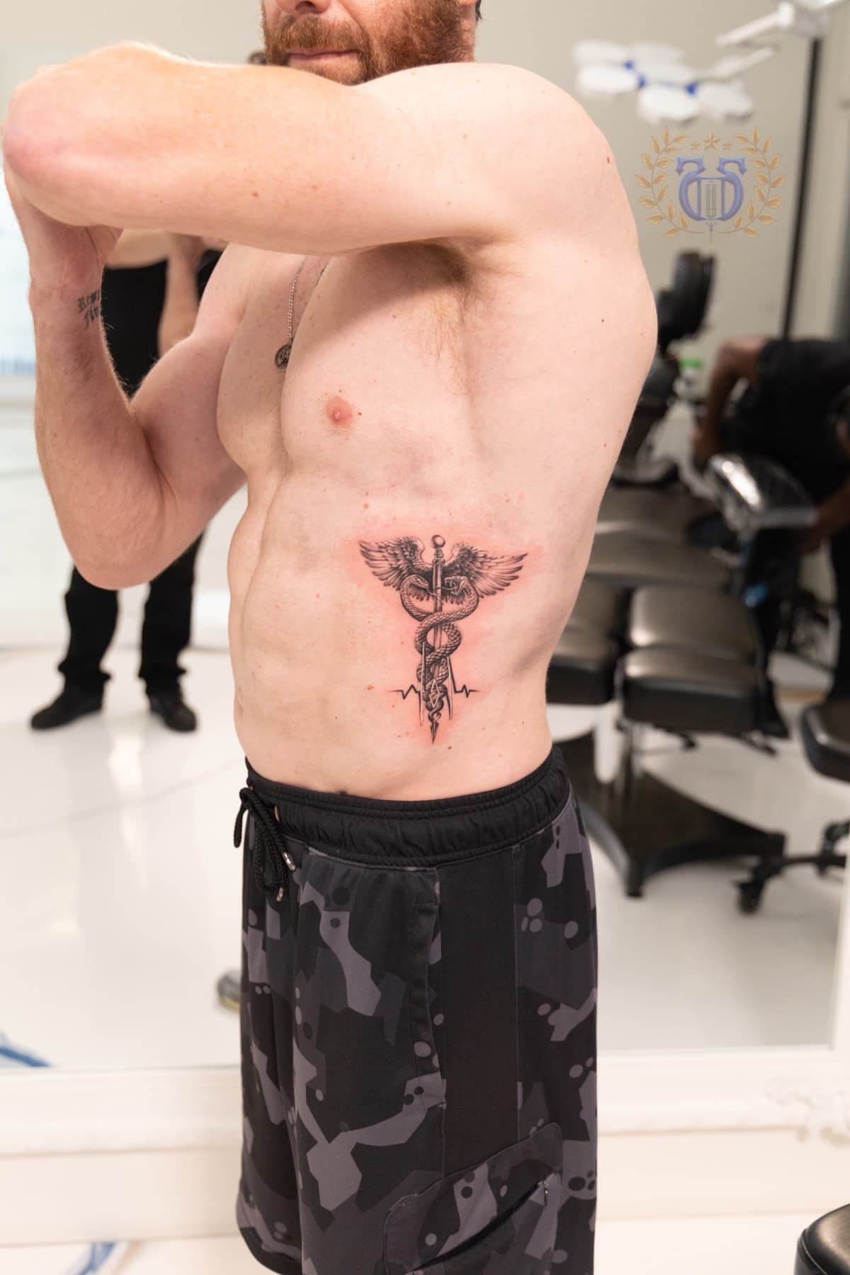 Black and grey caduceus medical symbol with heartbeat realism tattoo in Los Angeles