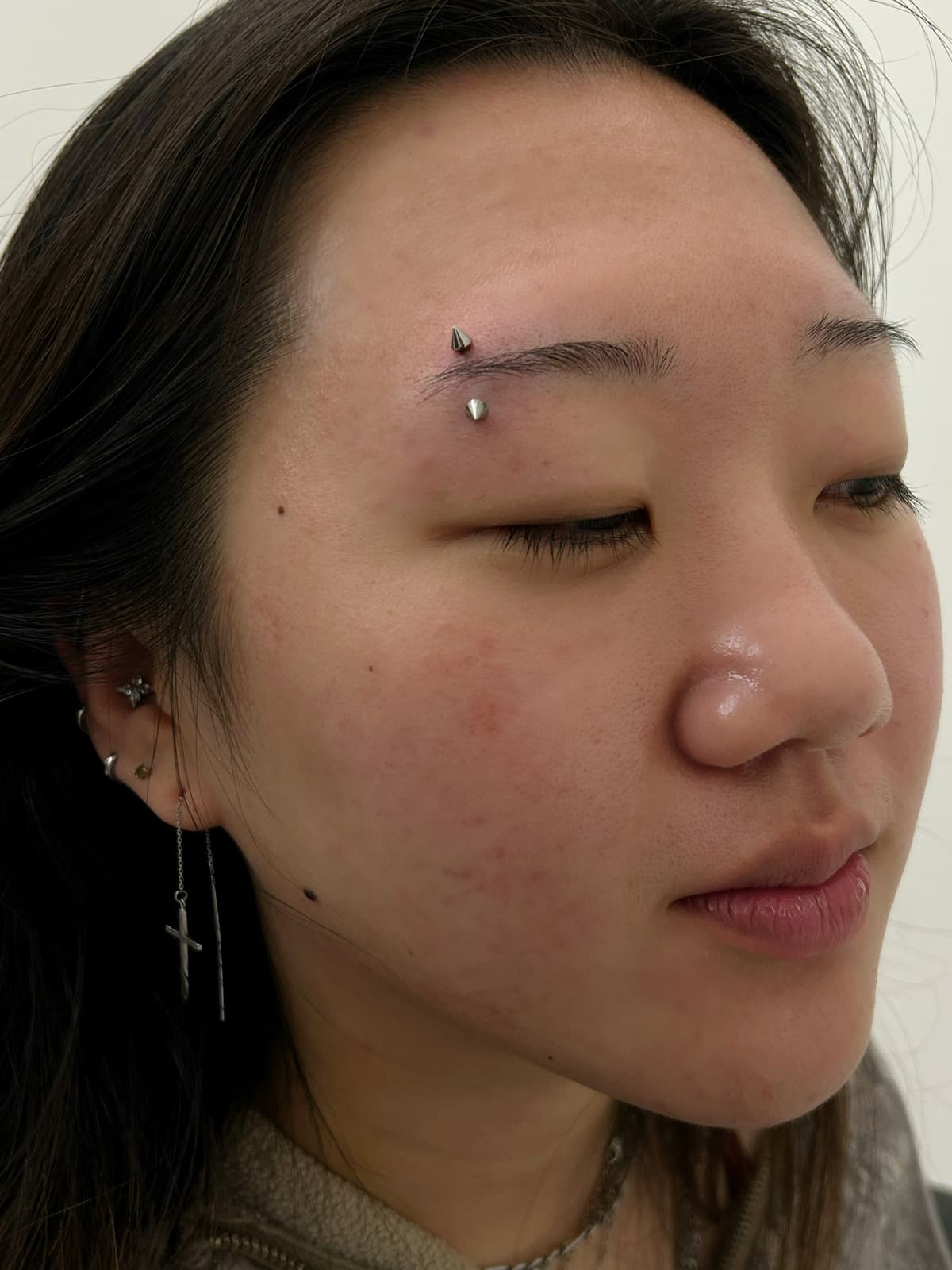 Eyebrow piercing with silver curved barbell on male client at Apollo Studio